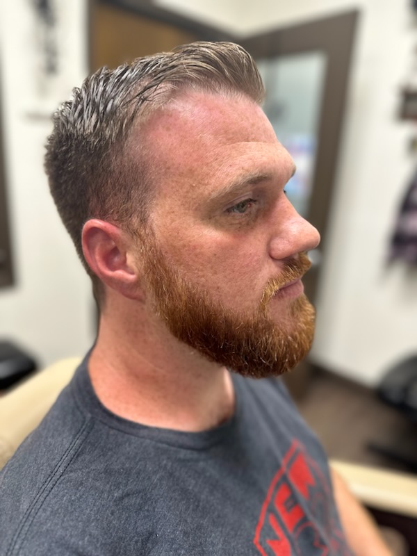 Client in the barber chair after a haircut and beard trim
